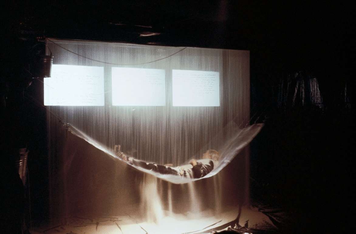 Judith Barry, “pastpresentfuturetense…ppft,” 1977. Performance still: sand curtain as it releases from the ceiling. Courtesy of Judith Barry and Mary Boone Gallery.