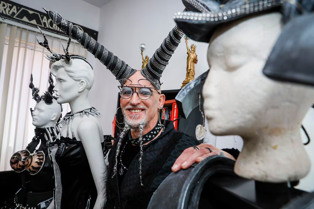 Gearóid Dolan, an activist and artist originally from Dublin, poses for a portrait with a few of the costumes that they have created in their Cambridge apartment. ERIN CLARK/GLOBE STAFF.